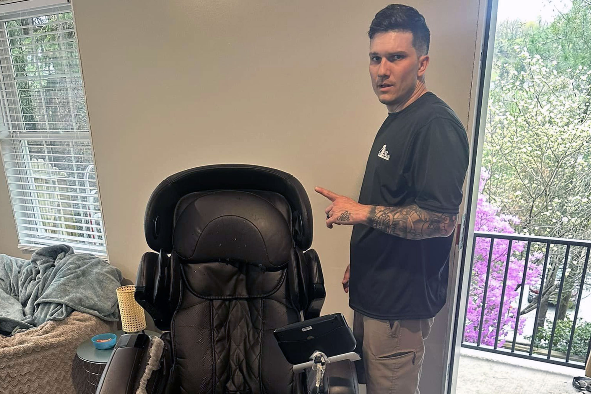 Mover getting a heavy massage chair ready to move in a living room