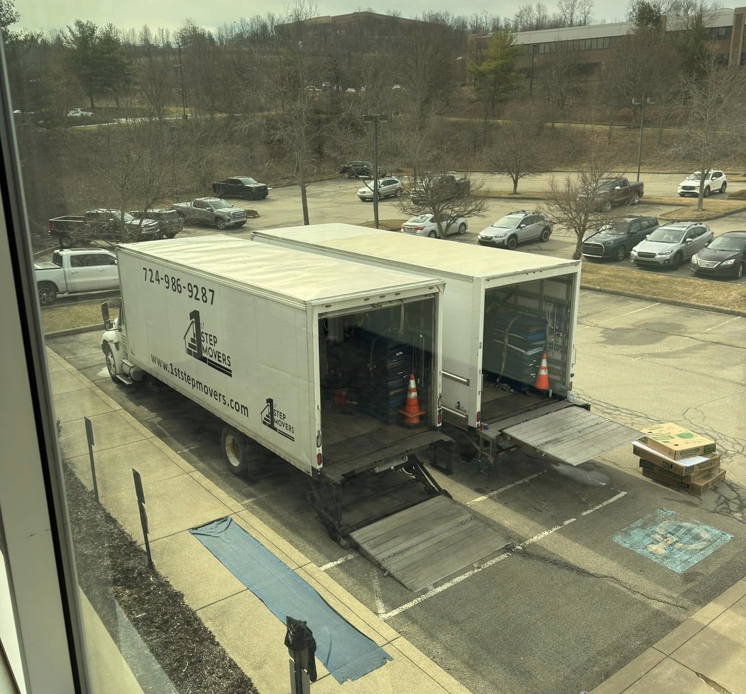 Two 1st Step trucks parked at a loading area seen from an upper floor window