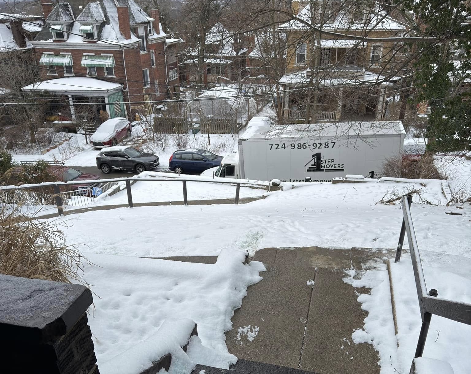 1st Step truck parked on a snowy street in a hillside neighborhood