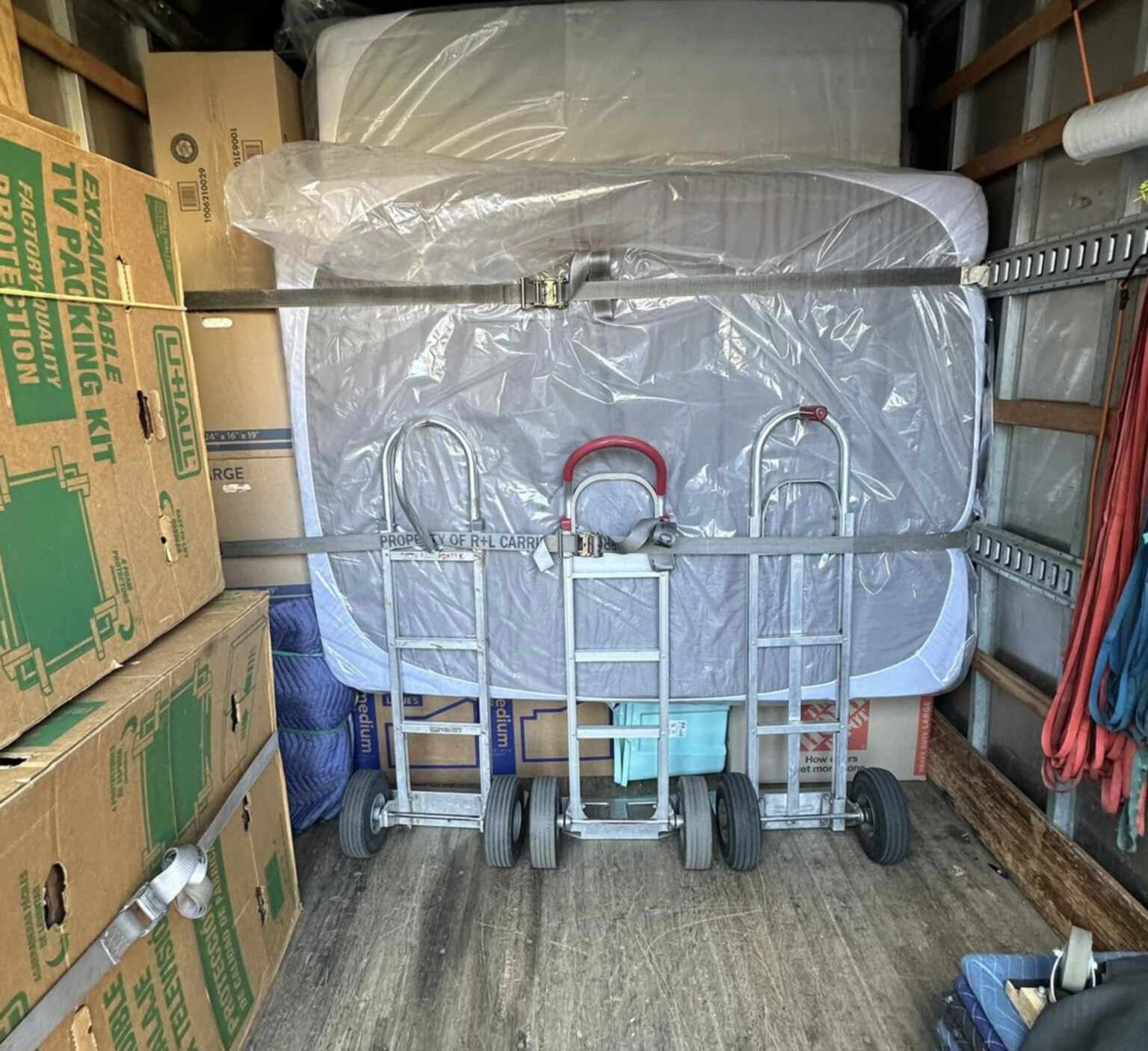 Packed 1st Step truck with a wrapped mattress and hand trucks strapped in place