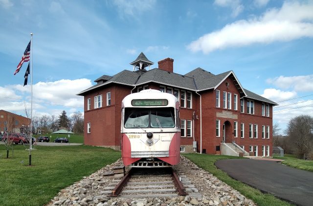 Schoolhouse Arts and History Center with a red and white trolley car on display in Bethel Park, PA